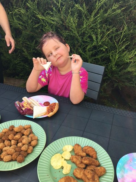 Liv enjoying her chicken nuggets and pizza